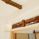 「古い部材を可能な限り活用する」が基本方針でリノベーションを行いました。旧い欄間を再活用しています。斜天井として太鼓梁もアラワシ仕上げとしました。 さんむの家 太鼓梁