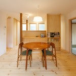 少し高さのある造作家具で雑然としがちなキッチンを仕切ります。右側の天井までの家具は冷蔵庫置き場です。掲示スペースとして利用できます。本好きのオーナー様に合わせて本棚を設置。天井高は2,200㎜です。 さんむの家 LDK